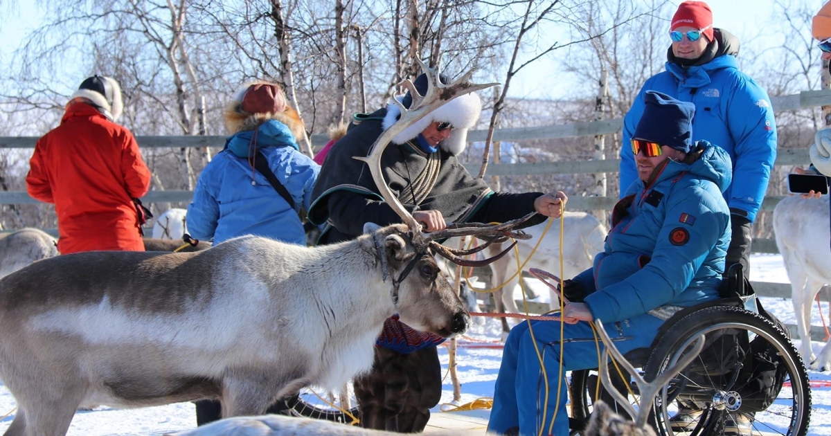 Mennesker i rullestol som hilser på reinsdyr i Kautokeino