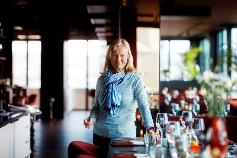 Kvinne som står ved et restaurantbord. Foto