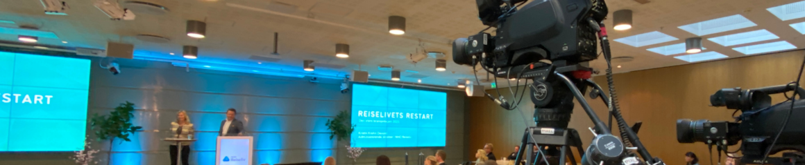Bilde av kamera og Kristin Krohn Devold sammen med Arne Hjeltnes på scenen under Reiselivets Bransjedag 2021