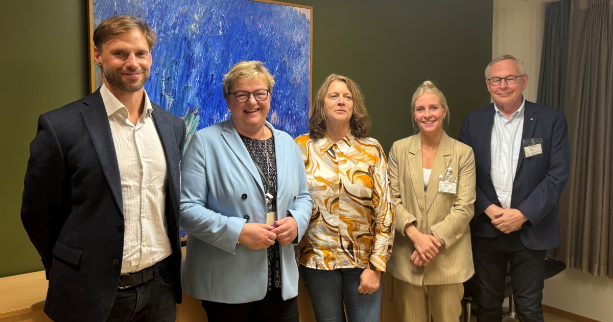 Fem personer oppstilt og ser i kamera