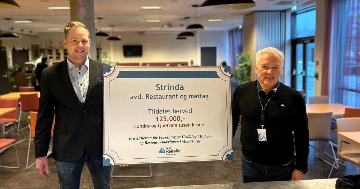 2 mennesker blir tatt bilde av, hvor de har holder en plakat hvor det fremkommer en pengesum som blir delt ut til Strinda vgs. avdeling Restaurant- og matfag