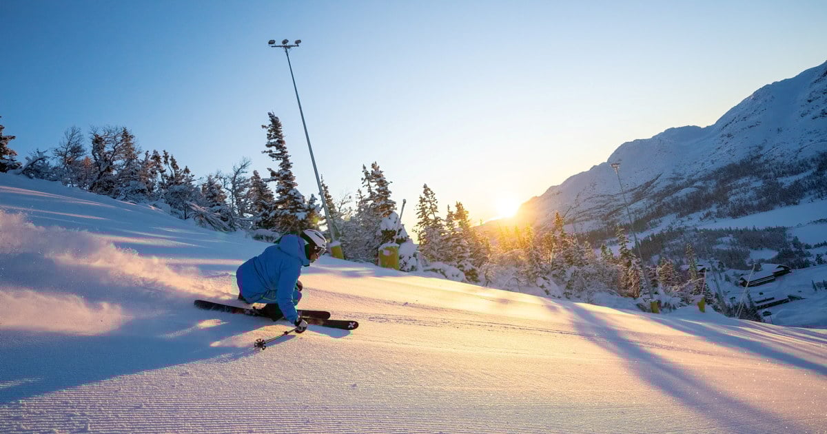 Slalåmkjører i morgensol på nypreparert snø