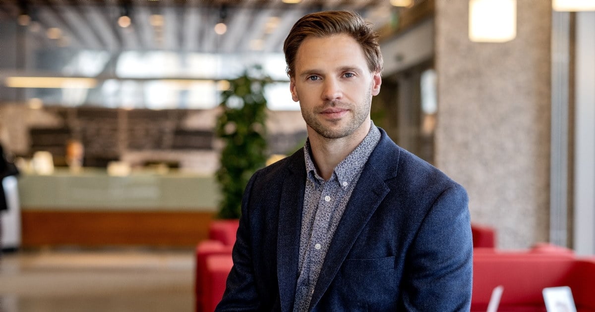 Portrett av sittende mann som ser inn i kamera. Foto.