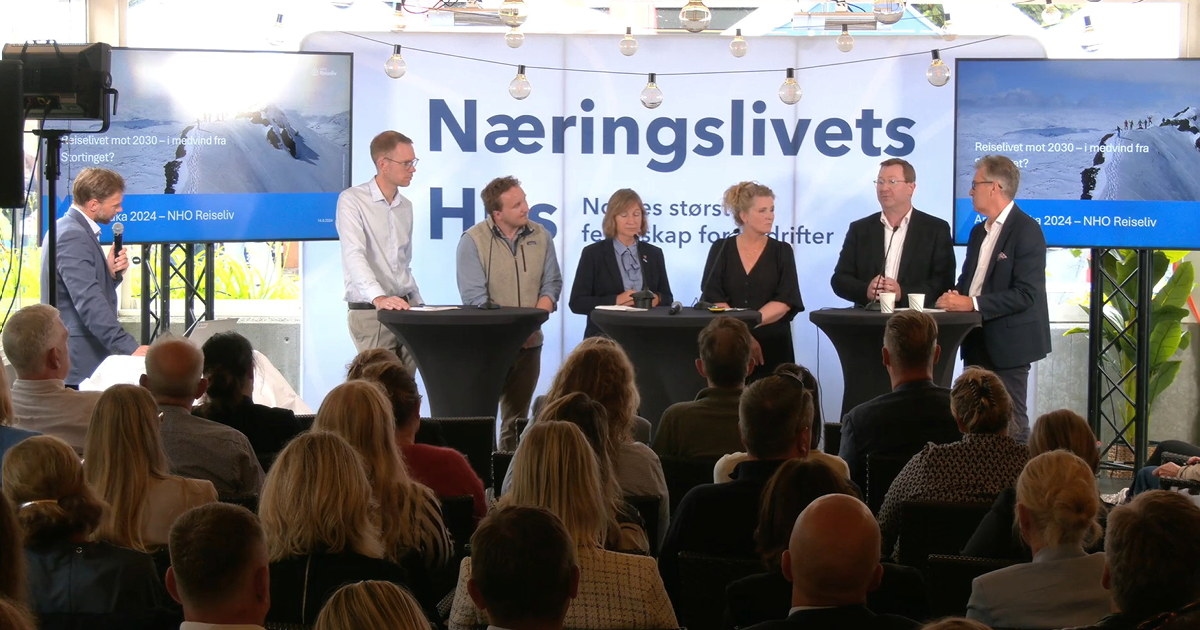 personer som står bak bord på en scene. Foto