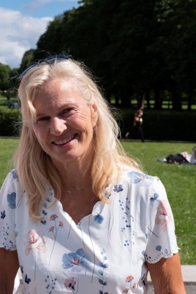 en smilende kvinne i sommervær. Foto
