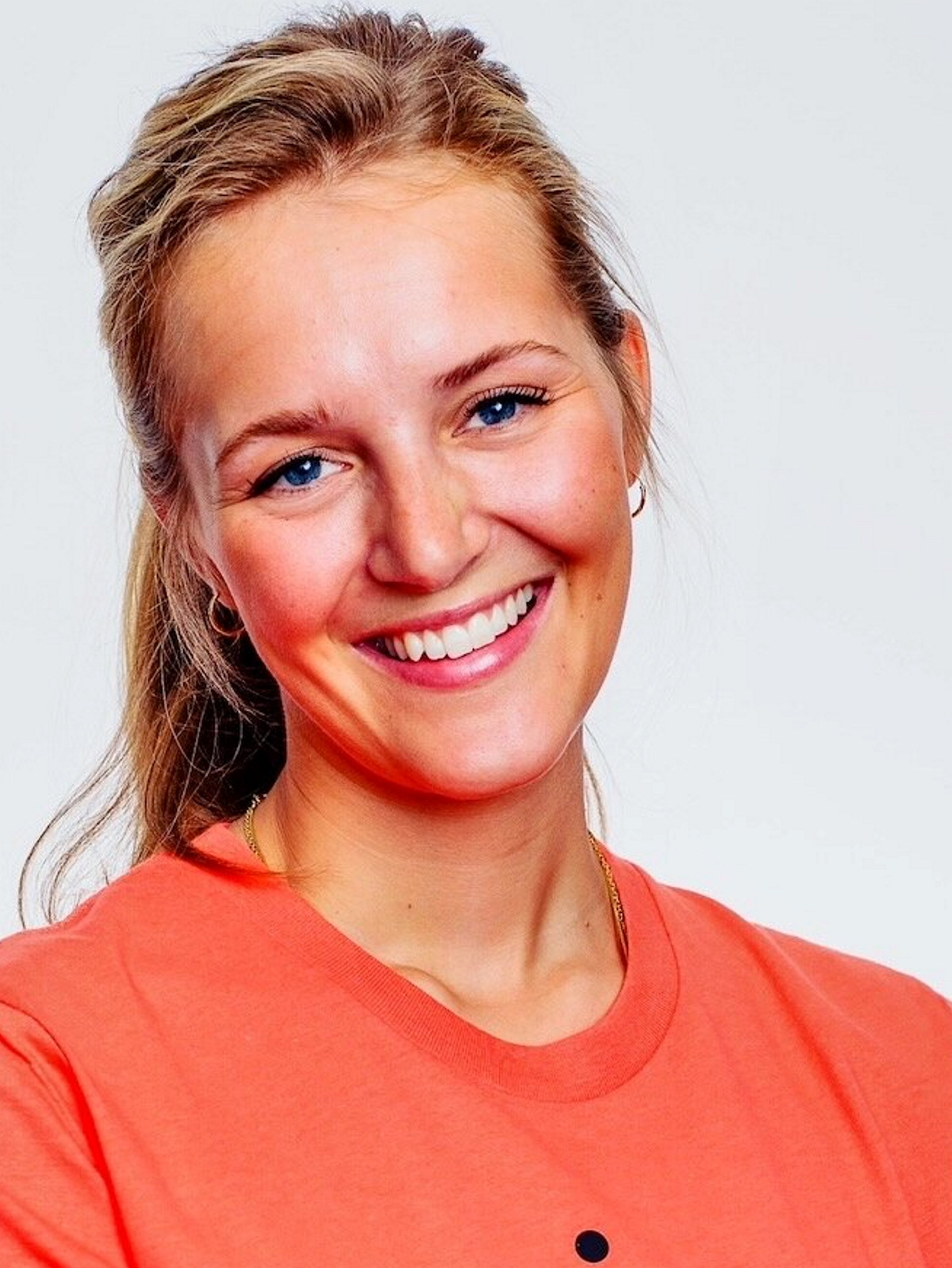 En kvinne med lyst hår som smiler. Foto