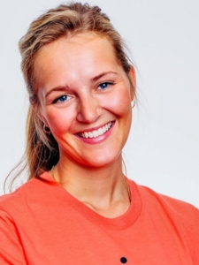 En kvinne med lyst hår som smiler. Foto