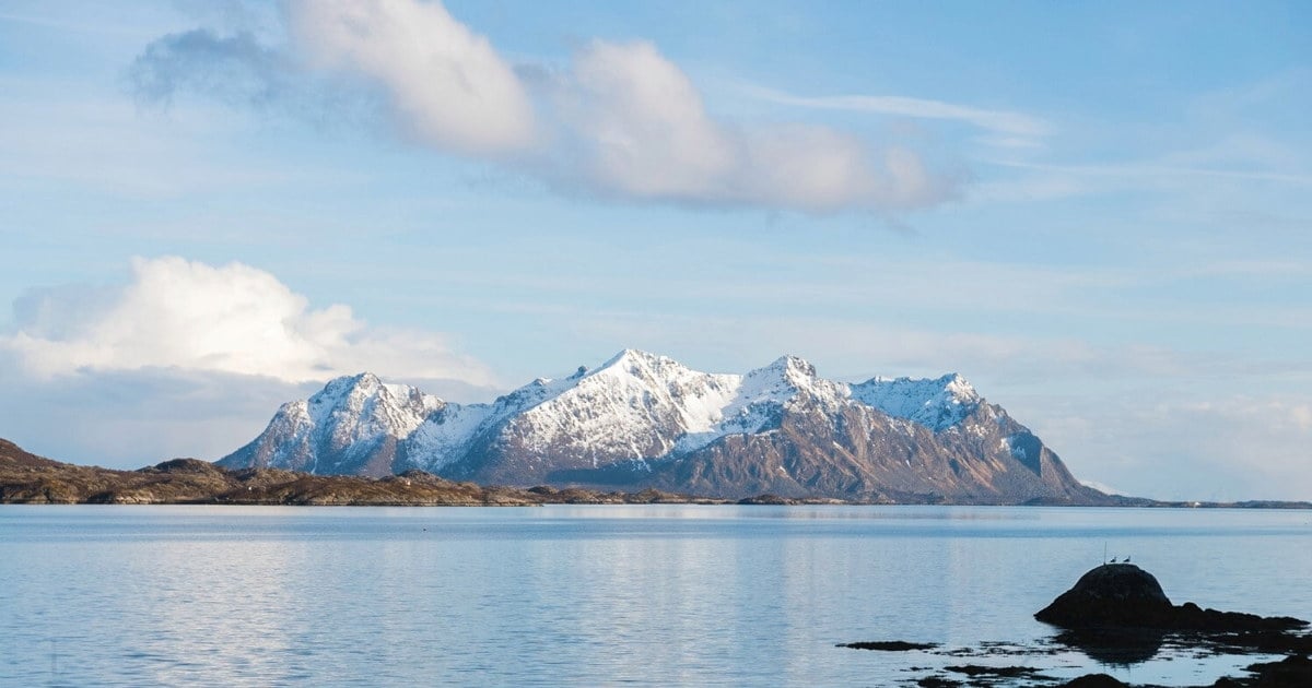 Naturbilde av vannet, et fjell og skyer på himmelen. Foto.