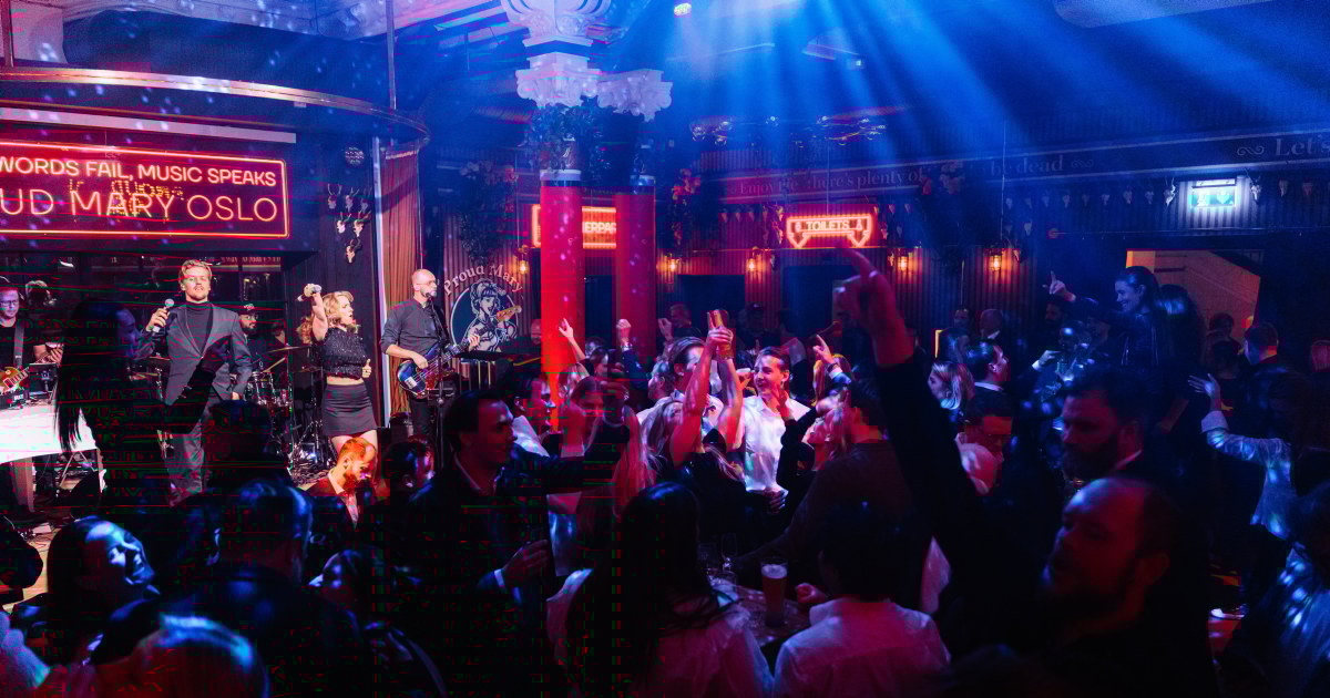 Stemningsfullt bilde hvor et band står på scenen og piller og mennesker danser