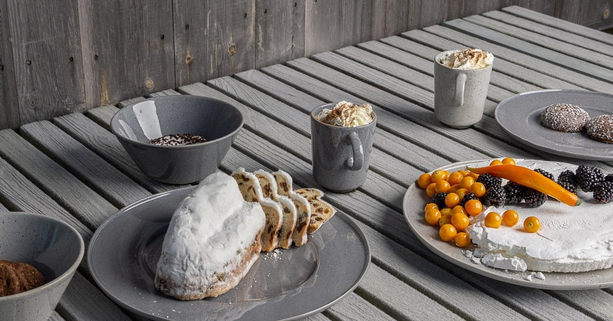 Grått servise med fargerikt anrettet mat på grått bord