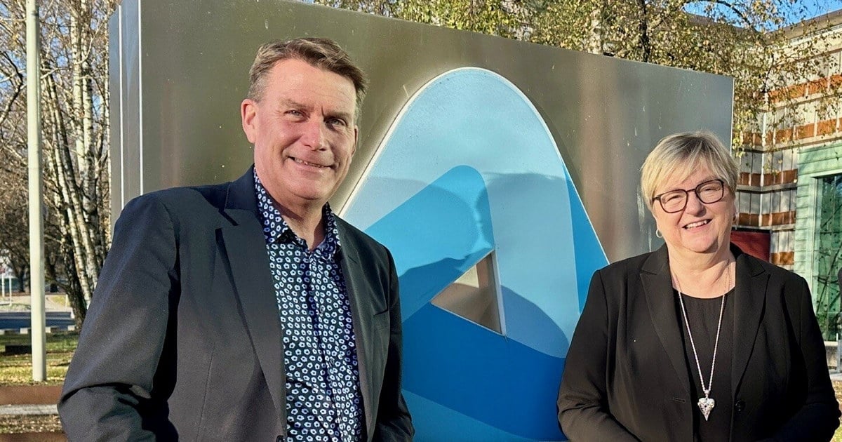 Kårstein Eidem Løvaas og Mona Saab som står ved NHO-logoen utenfor Næringslivets hus i Oslo