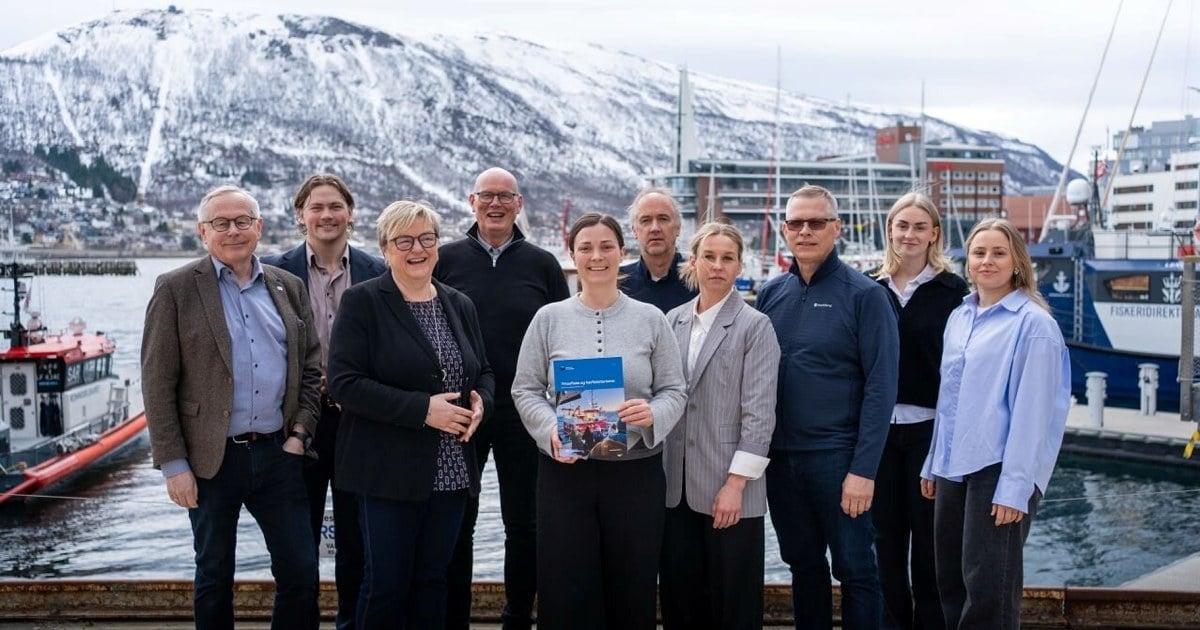 En gruppe mennesker som poserer for et foto på en bryggekant. Kvinnen i midten holder en rapport i hendene.