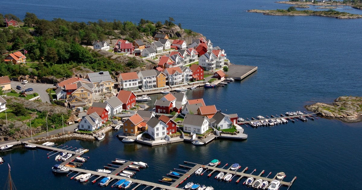 Flyfoto av mange fargerike hus ved vannet. Foto,