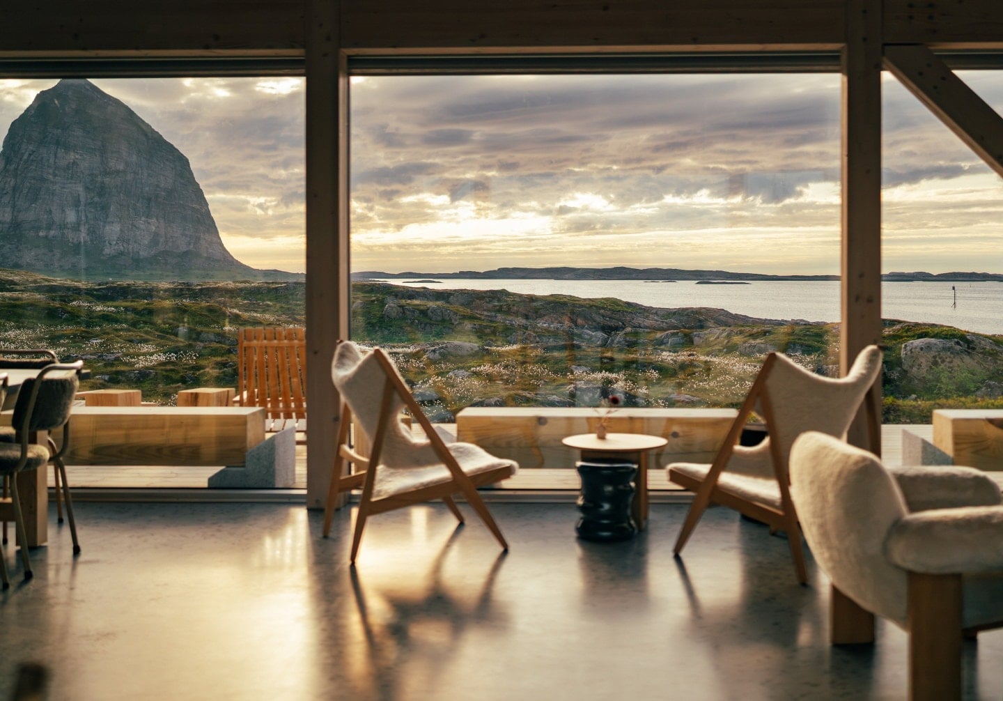 Interiør med store vinduer mot havet og fjellandskapet på Træna. Foto.