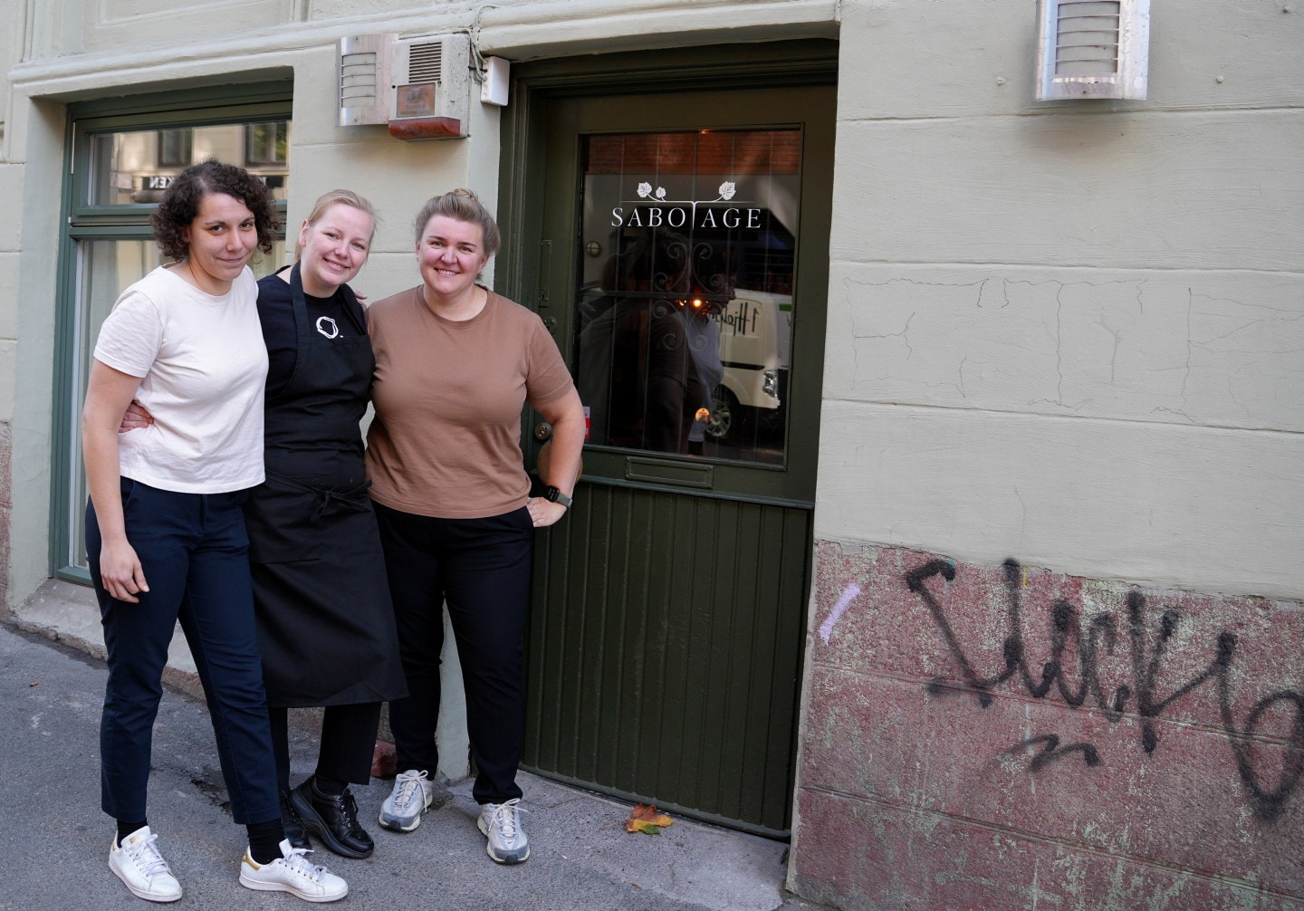 Tre personer står sammen ved inngangen til Sabotage.