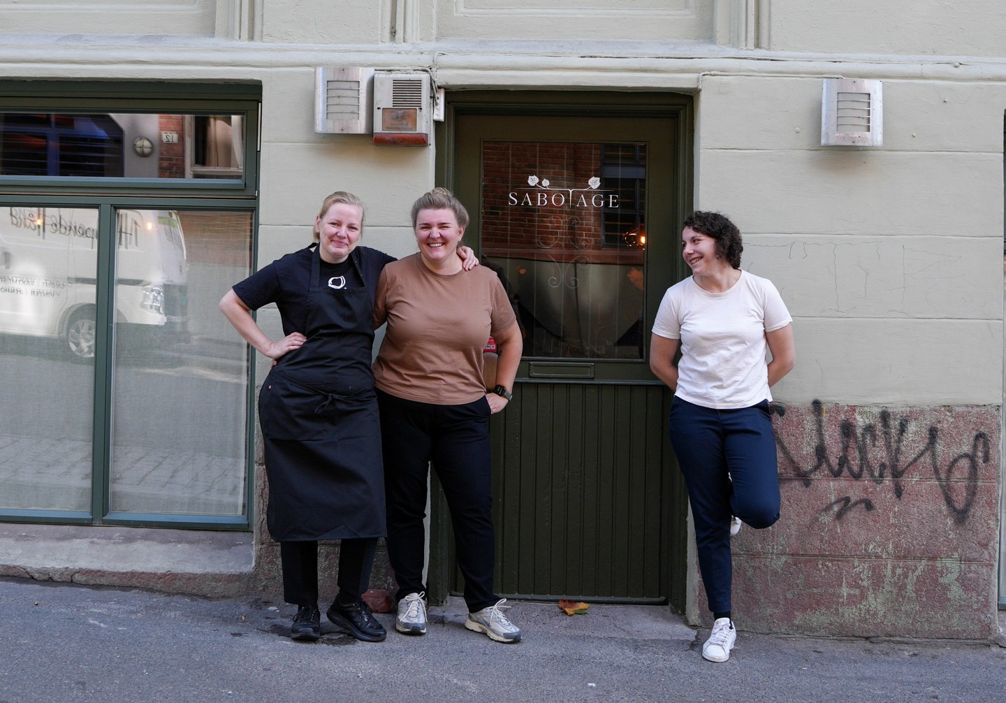 Tre personer står sammen ved inngangen til Sabotage.