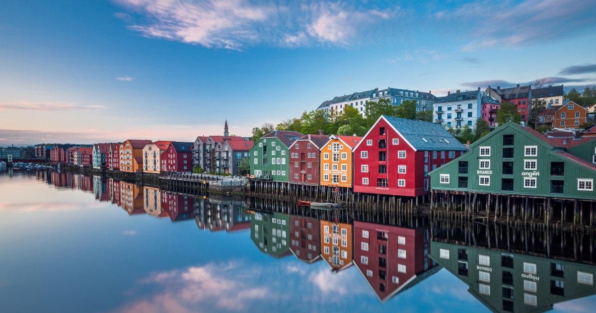 Fargerike trehus langs vannet. Foto.