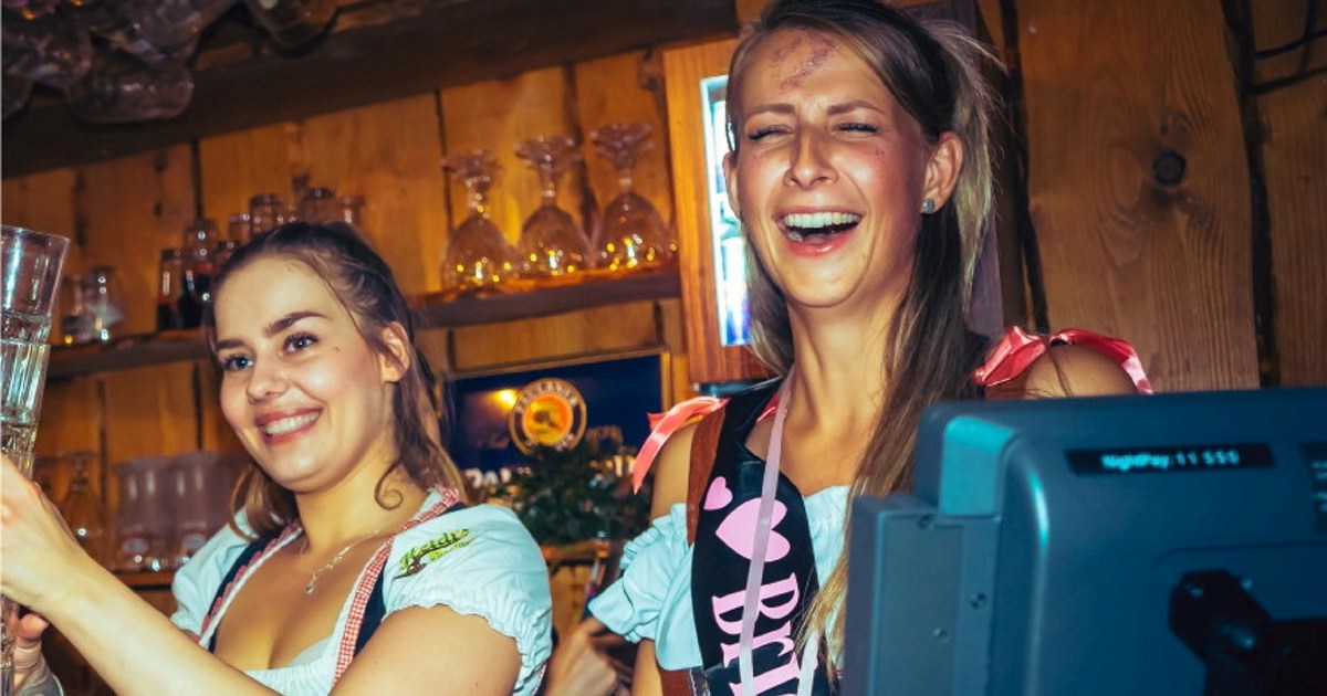 To blide jenter som står i en bar og mikser drinker