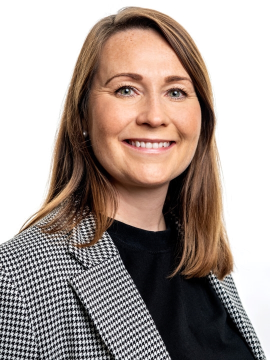 Kvinne som smiler mot kamera. Foto