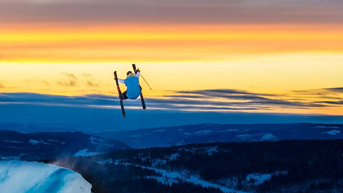 Mann hopper på ski i solnedgangen på Skeikampen Resort.