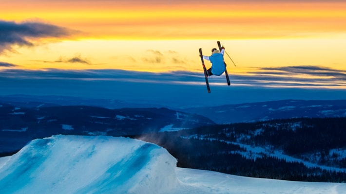 Mann hopper på ski i solnedgangen på Skeikampen Resort.