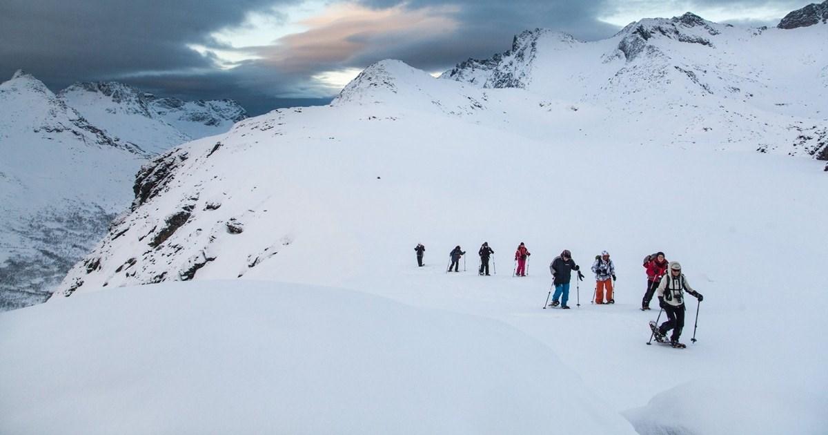 Mennesker på trugetur på et fjell med masse snø.
