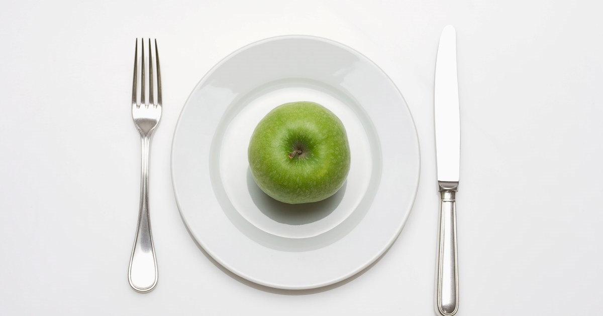 Bestikk, tallerken og eple. Illustrasjonsbilde.