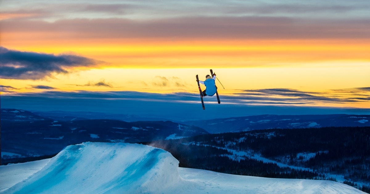 En person som hopper på ski i solnedgangen på Skeikampen Resort. Foto.