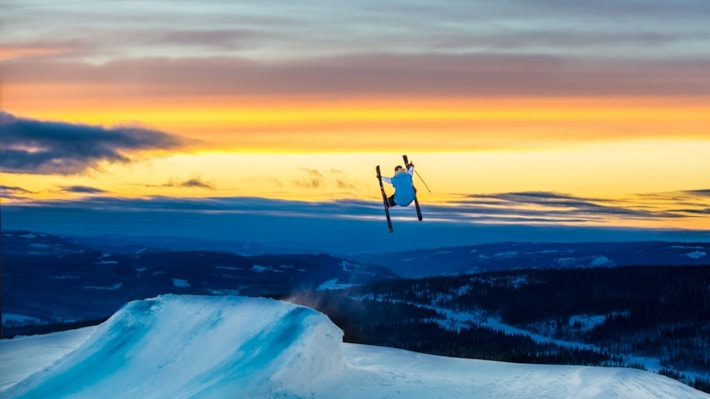 En person som hopper på ski i solnedgangen på Skeikampen Resort. Foto.