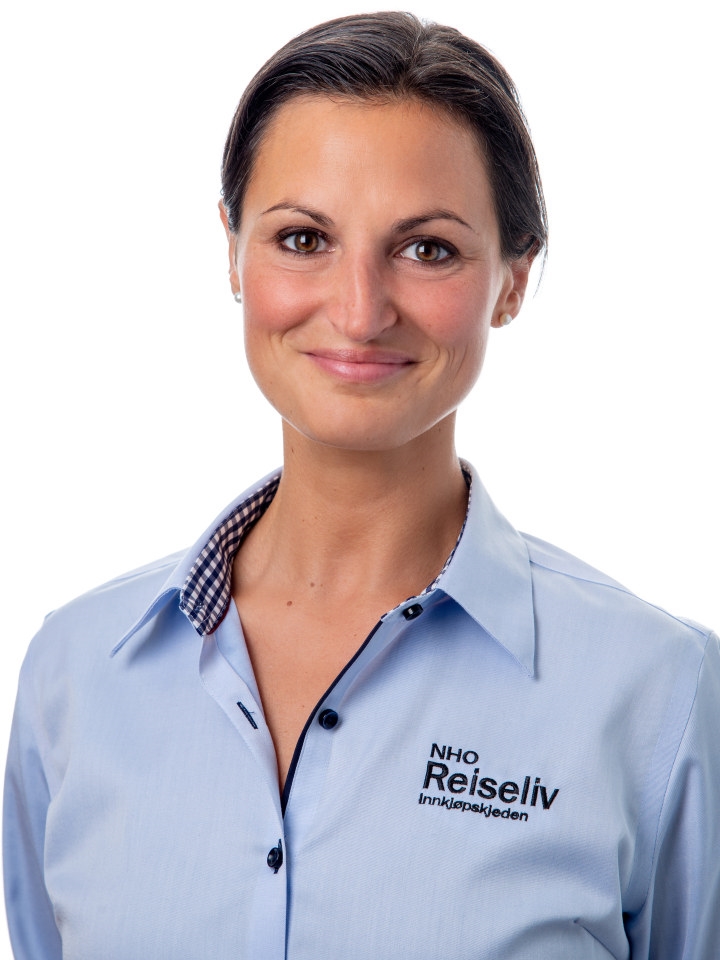 Portrettbilde av en blid kvinne i blå skjorte. Foto.