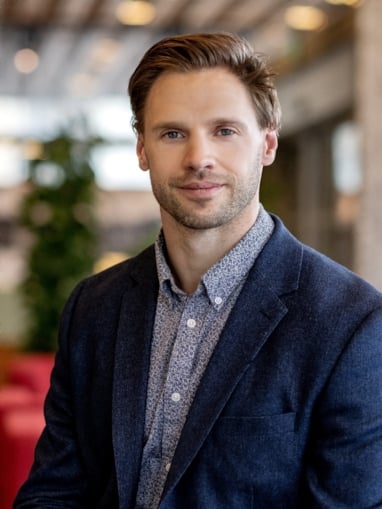 Smilende mann som ser inn i kamera. Foto