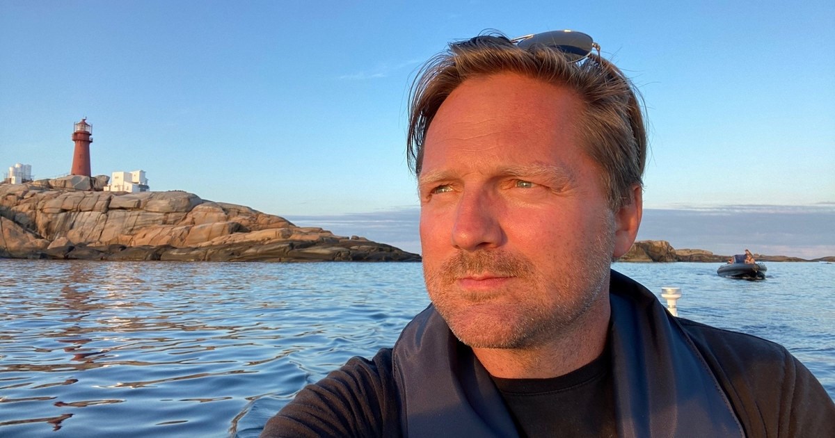 Rune Bjerkelund med redningsvest sittende i en båt på sjøen.