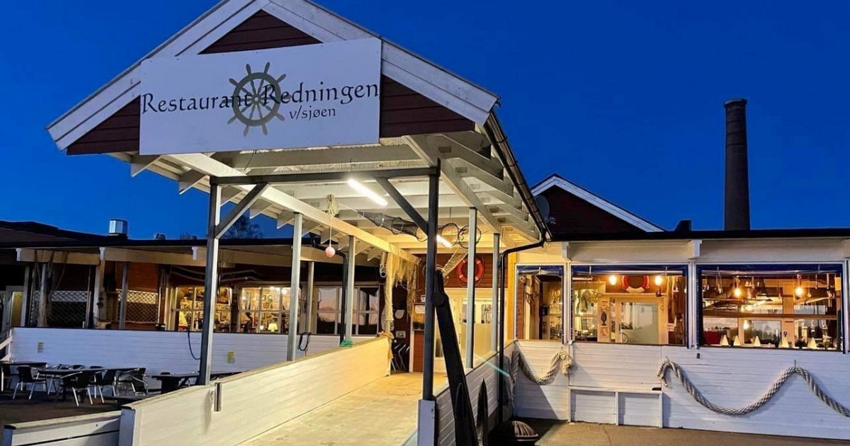Bilde av inngang hos restaurant Redningen. Rødt bygg på brygge.