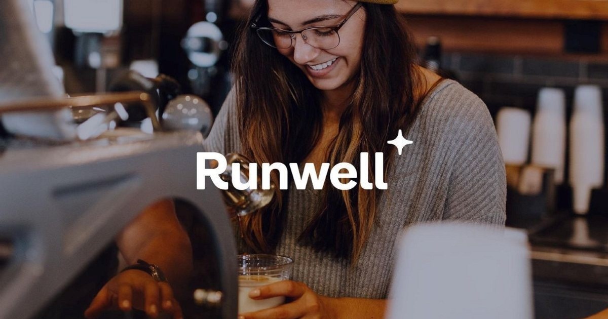 Ansatt som står ved en kaffemaskin og lager kaffe med logoen Runwell