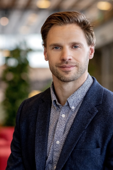 Smilende mann som ser inn i kamera. Foto