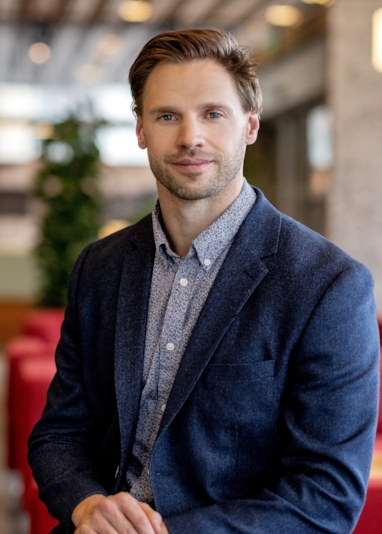 Smilende mann som ser inn i kamera. Foto
