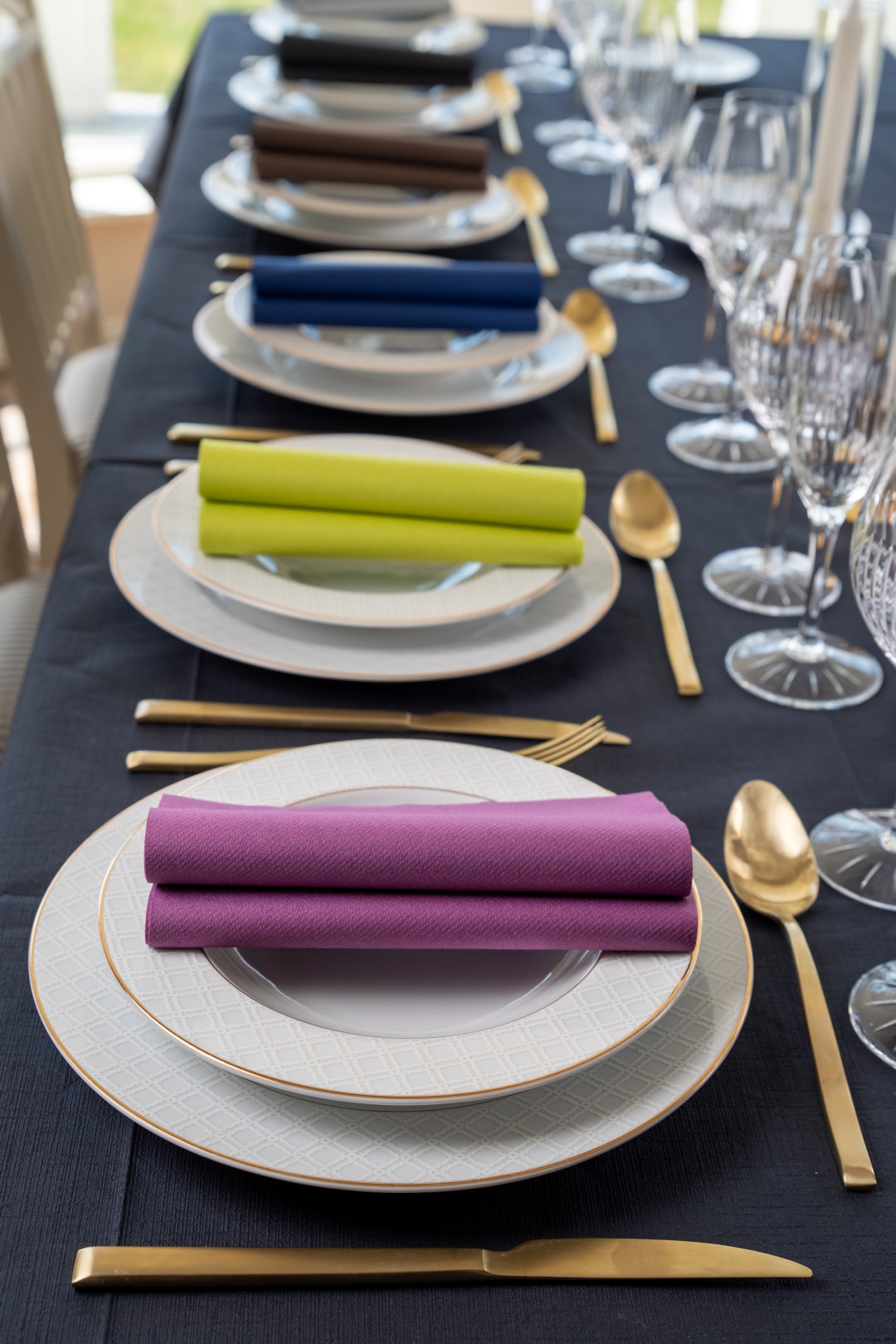 Bord dekket med hvite asjetter med fargerike servietter