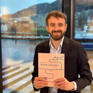 En kvinne som intervjues av to journalister, med mikrofon og kamera. Foto