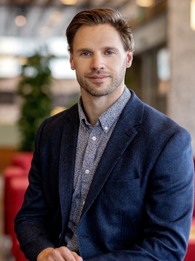 Smilende mann som ser inn i kamera. Foto