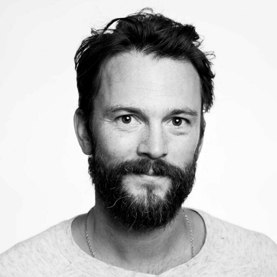 Portrettfoto av en mann med skjegg og bart. Sort/hvitt foto.