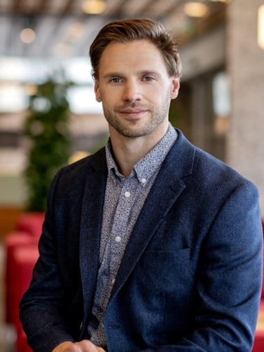 Smilende mann som ser inn i kamera. Foto