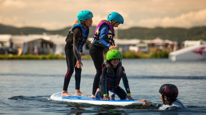 Barn på SUP-board på Norsjø Ferieland. Foto.