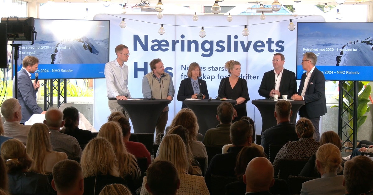 personer som står bak bord på en scene. Foto